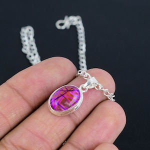 May include: A silver chain necklace with a pendant featuring a purple and orange oval gemstone.