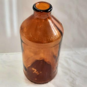 Op de afbeelding: Een bruine glazen fles met een brede opening en een etiket met de tekst "NEW YORK NO."