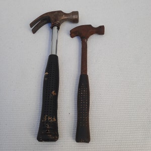 Two old iron hammers. Primitive hand tool. Decor. A set of hammers. Rusty tools.