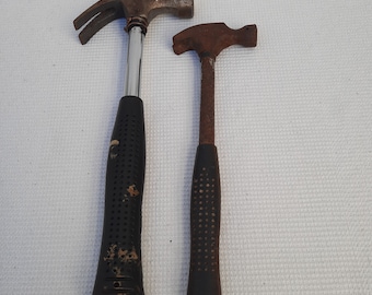 Two old iron hammers. Primitive hand tool. Decor. A set of hammers. Rusty tools.