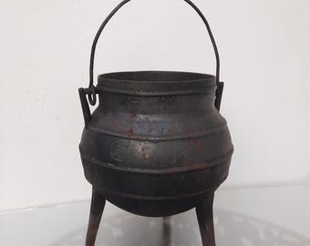 Panela de ferro fundido vintage. Painel antigo com pernas. Utensílios de cozinha tradicionais portugueses primitivos. Caldeirão de bruxa.