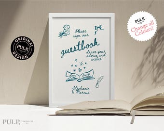May include: A white framed sign with a teal blue inscription that reads "Please sign our guestbook" with a whimsical illustration of a book, a quill pen, and stars. The text also includes "Leave your advice and wishes" and "Love always" with the names "Stephanie & Marcus" at the bottom.