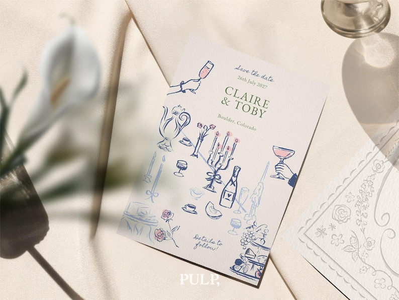 K&ouml;nnte beinhalten: Eine cremefarbene Hochzeitseinladung mit blauen und rosa Illustrationen eines Teeservices, Sektgl&auml;sern und einer mehrst&ouml;ckigen Torte. Der Text lautet "Save the date" und k&uuml;ndigt "Claire & Toby" mit Datum und Ort an.