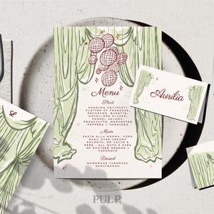 May include: A menu and place cards with a vintage design. The menu features a green curtain illustration and a list of dishes. The place cards have the name "Aurilia" and initials. The design includes a disco ball graphic.