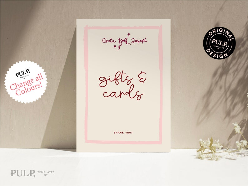 Pode incluir: Um cart&atilde;o branco com uma borda rosa e o texto "Greta & Joseph" em uma fonte manuscrita. O texto "gifts & cards" est&aacute; escrito em uma fonte manuscrita maior em cor bord&ocirc;. O texto "Thank You!" est&aacute; escrito em uma fonte menor na parte inferior do cart&atilde;o.