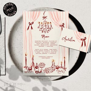 May include: A menu and place card set with a vintage design. The menu features a chandelier illustration and a list of Italian dishes. The place card has the name "Aurilia" in elegant script. Both are decorated with pink ribbons.