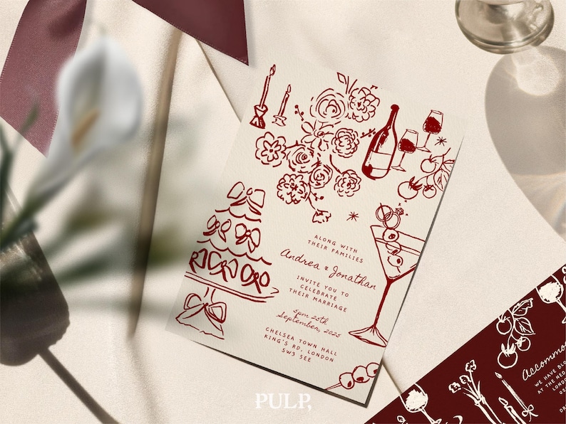 May include: Wedding invitation with a burgundy illustration of a cake, flowers, wine, and martini glasses. The invitation includes the names Andrea and Jonathan, along with the date and location.