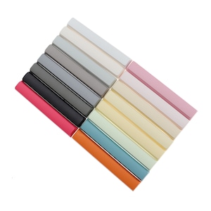 May include: A set of 15 colorful keycaps for a mechanical keyboard. The keycaps are arranged in a rainbow pattern, with shades of gray, pink, white, yellow, green, blue, and orange.