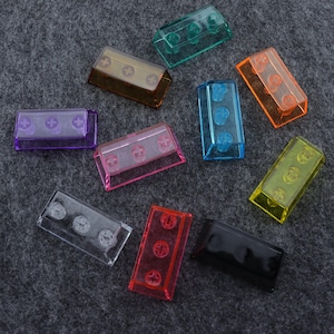 Peut inclure: Assortiment de dix touches de clavier en plastique coloré avec un design de type Lego. Les touches sont translucides et se déclinent en plusieurs couleurs, notamment le violet, le rose, le bleu, le vert, le jaune, l'orange et le transparent.