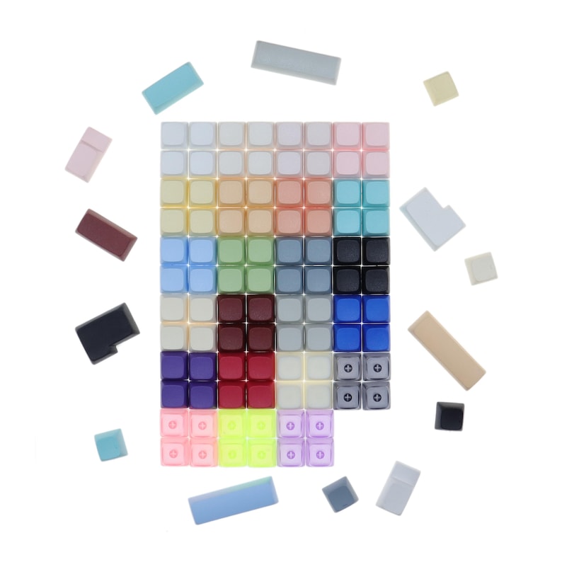 Puede incluir: Un surtido de teclas de colores para un teclado mec&aacute;nico. Las teclas est&aacute;n dispuestas en una cuadr&iacute;cula y incluyen varios colores como rojo, azul, verde, amarillo y morado.