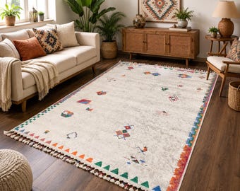 May include: A rectangular area rug featuring a light cream base with a distressed texture. The border displays a repeating pattern of green, orange, and blue triangles. Small, scattered geometric motifs in red, blue, and green accent the center.