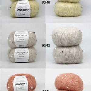 Pu&ograve; includere: Due gomitoli di filato giallo con paillettes argentate, due gomitoli di filato beige con paillettes argentate e due gomitoli di filato pesca con paillettes argentate. Il filato &egrave; etichettato "Lana Gatto Polaris" e i gomitoli sono impilati uno sopra l'altro. I numeri 9340, 9343 e 9341 sono stampati sull'immagine.
