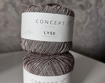 May include: Two spools of Katia Concept Lyse yarn, made of linen and cotton. The yarn is a mix of brown and white threads, creating a textured appearance. Each spool has a white label with the brand name and yarn type.