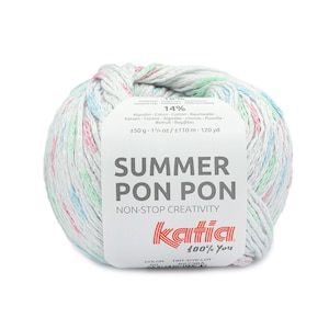 Può includere: Un gomitolo di filato bianco con macchie rosa, blu e verdi. Il filato è etichettato "Summer Pon Pon" e "Katia 100% You".