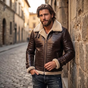 Könnte beinhalten: Eine dunkelbraune Lederjacke mit Krokodilleder-Optik, cremefarbenem Kunstfellfutter, breitem Kragen, durchgehendem Frontreißverschluss sowie verstellbaren Schnallenriemen an Ärmelbündchen und Kragen, kombiniert mit einer blauen Jeanshose.