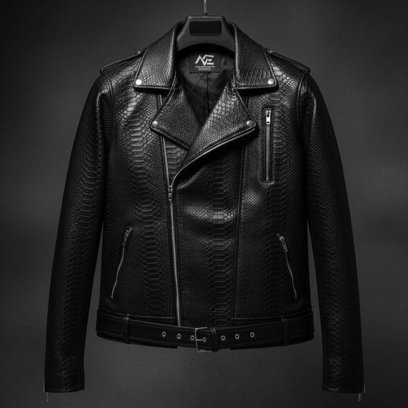 Może przedstawiać: Czarna sk&oacute;rzana kurtka o fakturze sk&oacute;ry węża, klasyczny styl motocyklowy z asymetrycznym zapięciem na zamek błyskawiczny. Posiada klapy z wycięciami, wiele kieszeni zapinanych na zamek i pasek w talii. Kurtka wisi na czarnym wieszaku.