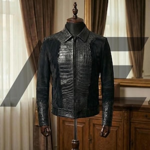 Könnte beinhalten: Schwarze Lederjacke mit einem krokodiltexturierten Frontpanel und Kragen. Die Jacke hat einen Reißverschluss und wird auf einer Schaufensterpuppe präsentiert. Die Ärmel haben ein strukturiertes Design an den Manschetten. Die Jacke ist dunkel.