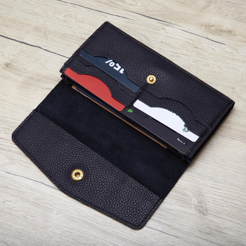 An open black leather wallet with a few credit cards visible inside.