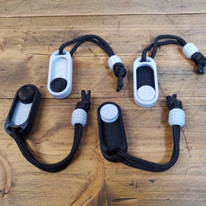 Peut inclure: Quatre porte-clés noirs et blancs avec une boucle et un petit bouton. Chaque porte-clés a un design différent.