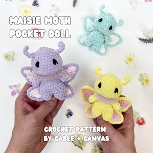 May include: Crochet pattern for a "Maisie Moth Pocket Doll" featuring three crocheted moths in purple, blue, and yellow. The pattern is by Cable + Canvas.