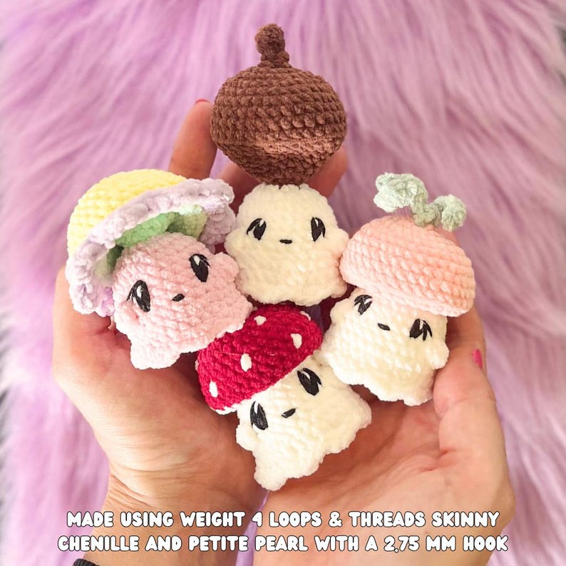 May include: A collection of handmade crochet mushroom and acorn figures in various colors, including pink, red, white, and brown. Each figure has a unique design and facial features. The text at the bottom reads "MADE USING WEIGHT 4 LOOPS & THREADS SKINNY CHENILLE AND PETITE PEARL WITH A 2.75 MM HOOK."