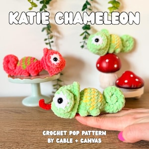 May include: Handmade crochet chameleons in pink and green with yellow accents. One pink chameleon sits on a small cake stand. The image includes the text "KATIE CHAMELEON" and "CROCHET POP PATTERN BY CABLE + CANVAS."