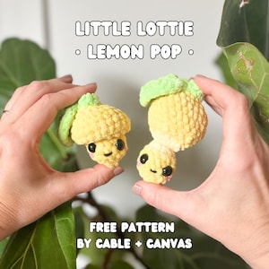 May include: Two crocheted lemon-shaped plushies with cute faces. The plushies are yellow with green leaves and are held in a person's hands. The text "LITTLE LOTTIE - LEMON POP - FREE PATTERN BY CABLE + CANVAS" is visible below the plushies.
