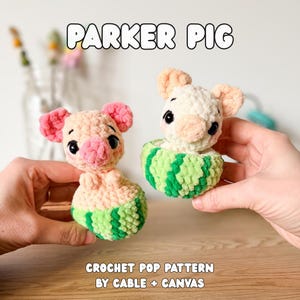 Puede incluir: Dos juguetes de cerdito hechos a mano con ganchillo, uno en una cesta con temática de sandía. Los cerdos son de color rosa y crema con ojos negros y orejas rosas. El texto "PARKER PIG" está encima de los juguetes. El texto "CROCHET POP PATTERN BY CABLE + CANVAS" está debajo.