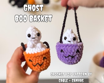 May include: Two small crochet ghost figures sitting in miniature baskets. One basket is orange and the other is purple, both featuring black embroidered faces. The ghosts have white yarn bodies and black safety eyes. Text reads GHOST BOO BASKET.