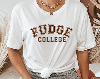Könnte beinhalten: Weißes T-Shirt mit braunem Text, der in einer College-Schriftart "FUDGE COLLEGE" lautet.