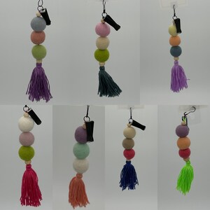 May include: Set of 6 colorful felt ball car air fresheners with a tassel. Each air freshener has a clip to attach to a car vent.