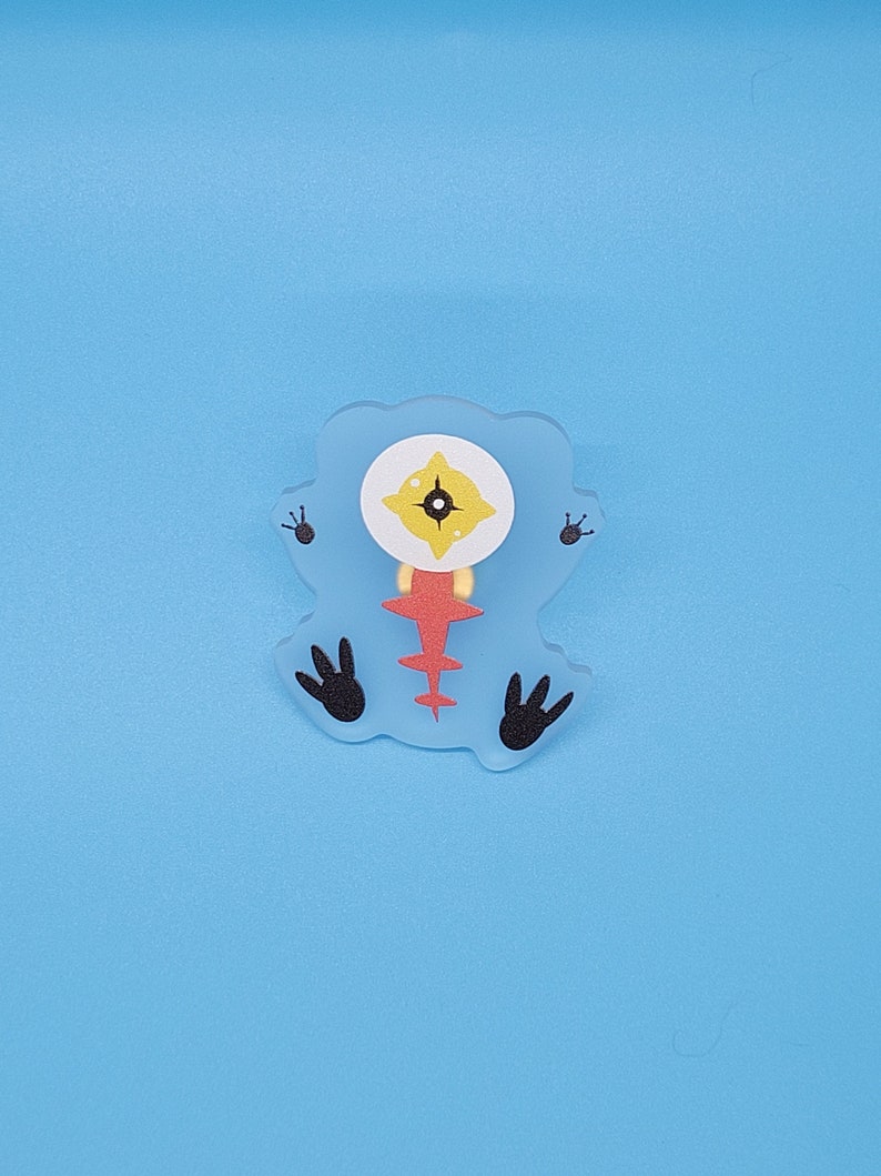 Puede incluir: Un monstruo de dibujos animados azul, rojo y amarillo con un ojo y cuatro patas. El monstruo est&aacute; hecho de fieltro y tiene un dise&ntilde;o cosido.