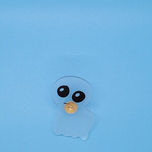 May include: A translucent blue ghost with black eyes and a gold coin in its mouth. The ghost is on a light blue background.