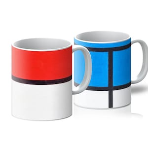 Pode incluir: Duas canecas de cerâmica branca com designs coloridos. Uma caneca apresenta uma parte superior vermelha, uma faixa preta e uma parte inferior branca. A outra caneca tem um design azul com linhas pretas e uma parte inferior branca. Ambas as canecas têm alças brancas.
