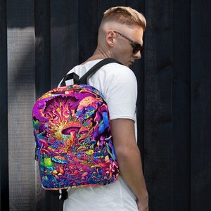 Może przedstawiać: Czarny plecak z kolorowym, psychodelicznym wzorem przedstawiającym grzyby i inne rośliny. Wzór jest żywy i zawiera odcienie różowego, fioletowego, niebieskiego, zielonego i żółtego.