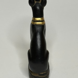 May include: Black ceramic statue of the Egyptian goddess Bastet, a cat with gold accents and hieroglyphics on the base.