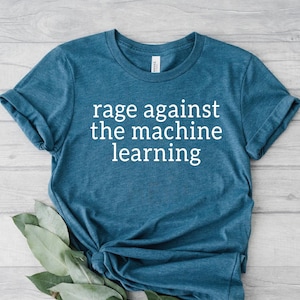 May include: A teal blue t-shirt with the text "rage against the machine learning" in white.