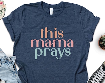 May include: A navy blue t-shirt with the text "this mama prays" in pink, peach, and light blue.