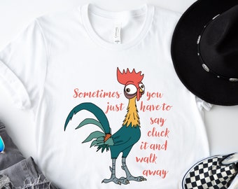 以下が含まれることがあります： 「Sometimes you just have to say cluck it and walk away」というテキストと、漫画の雄鶏が描かれた白いTシャツ。