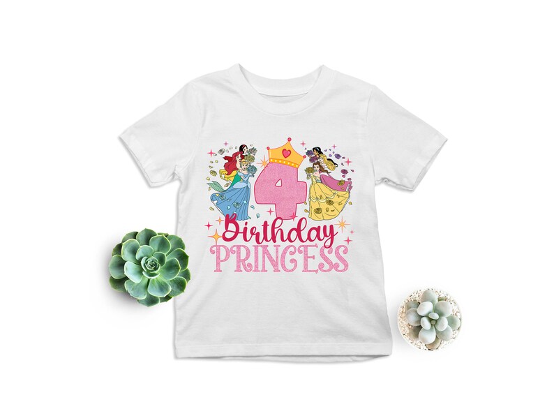 May include: White t-shirt with a pink number four, a crown, and three princesses in colorful dresses. The text "Birthday Princess" is written in pink below the number.