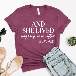 Puede incluir: Una camiseta color granate con el texto "AND SHE LIVED happily ever after #DIVORCED" en blanco.
