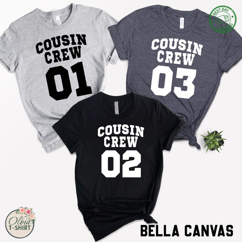 K&ouml;nnte beinhalten: Drei T-Shirts mit dem Text "COUSIN CREW" und den Zahlen 01, 02 und 03 in fetter, wei&szlig;er Schrift. Die Shirts sind grau, schwarz und marineblau. Der Markenname "BELLA CANVAS" ist schwarz gedruckt.