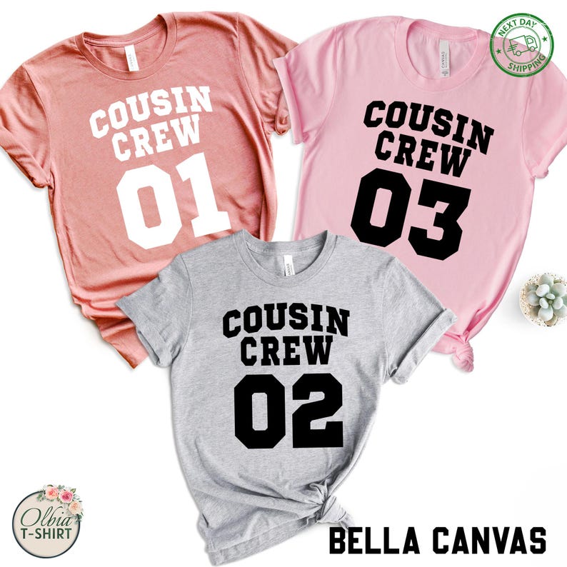 K&ouml;nnte beinhalten: Drei T-Shirts in Rosa-, Grau- und Rosat&ouml;nen. Jedes Shirt tr&auml;gt den Aufdruck "COUSIN CREW" in fetten schwarzen Buchstaben mit einer Nummer darunter. Die Nummern sind 01, 02 und 03. Die Shirts sind von der Marke Bella Canvas.