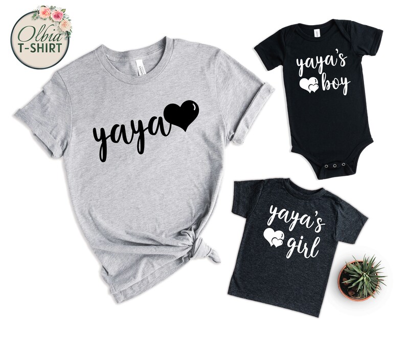 K&ouml;nnte beinhalten: Ein Set aus drei grauen T-Shirts mit schwarzem und wei&szlig;em Text und Herzmotiven. Die Shirts sagen "yaya" und "yaya's boy" und "yaya's girl".