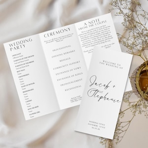 May include: Elegant white wedding program with black text. The program includes sections for the wedding party, ceremony details, and a welcome message. The names Jacob and Stephanie are featured.