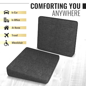 May include: Two grey wedge-shaped cushions, one on top of the other, on a wooden surface. The cushions are made of a soft, textured fabric. The text "COMFORTING YOU ANYWHERE" is visible in the background.