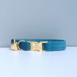 Puede incluir: Collar de terciopelo azul turquesa para gato con hebilla dorada y cascabel. La hebilla tiene el nombre "Milo" y el n&uacute;mero de tel&eacute;fono "021-5401-8996" grabados.