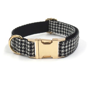 Op de afbeelding: Hondenhalsband met zwart-witte ruitjesprint en een gouden metalen gesp.