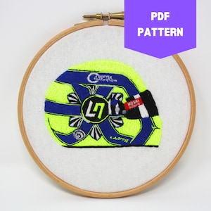 Può includere: Disegno ricamato di un casco da corsa giallo e blu con il numero "47" e il testo "Better Tomorrow" e "Whisky Throttle". Il disegno è in un cerchio da ricamo in legno.