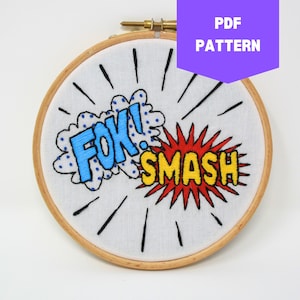 May include: Embroidered hoop art with a blue and white speech bubble saying "FOK!" and a red and yellow speech bubble saying "SMASH!"